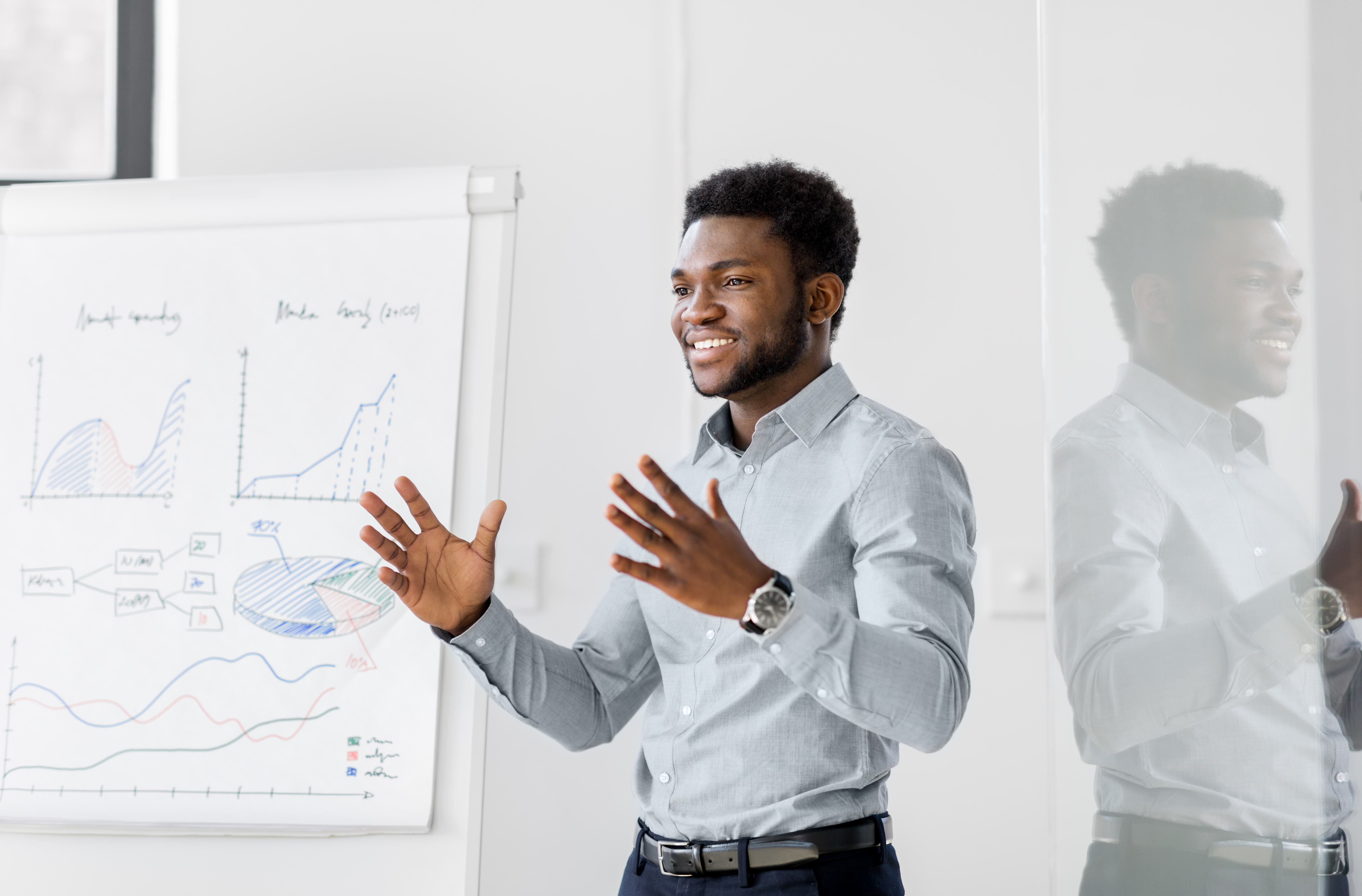african man teaching in front of white board