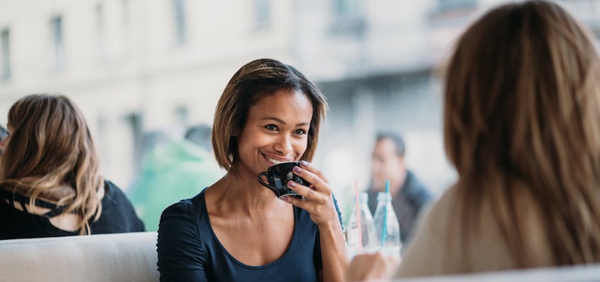 a young woman enjoying a one on one coaching session over coffee